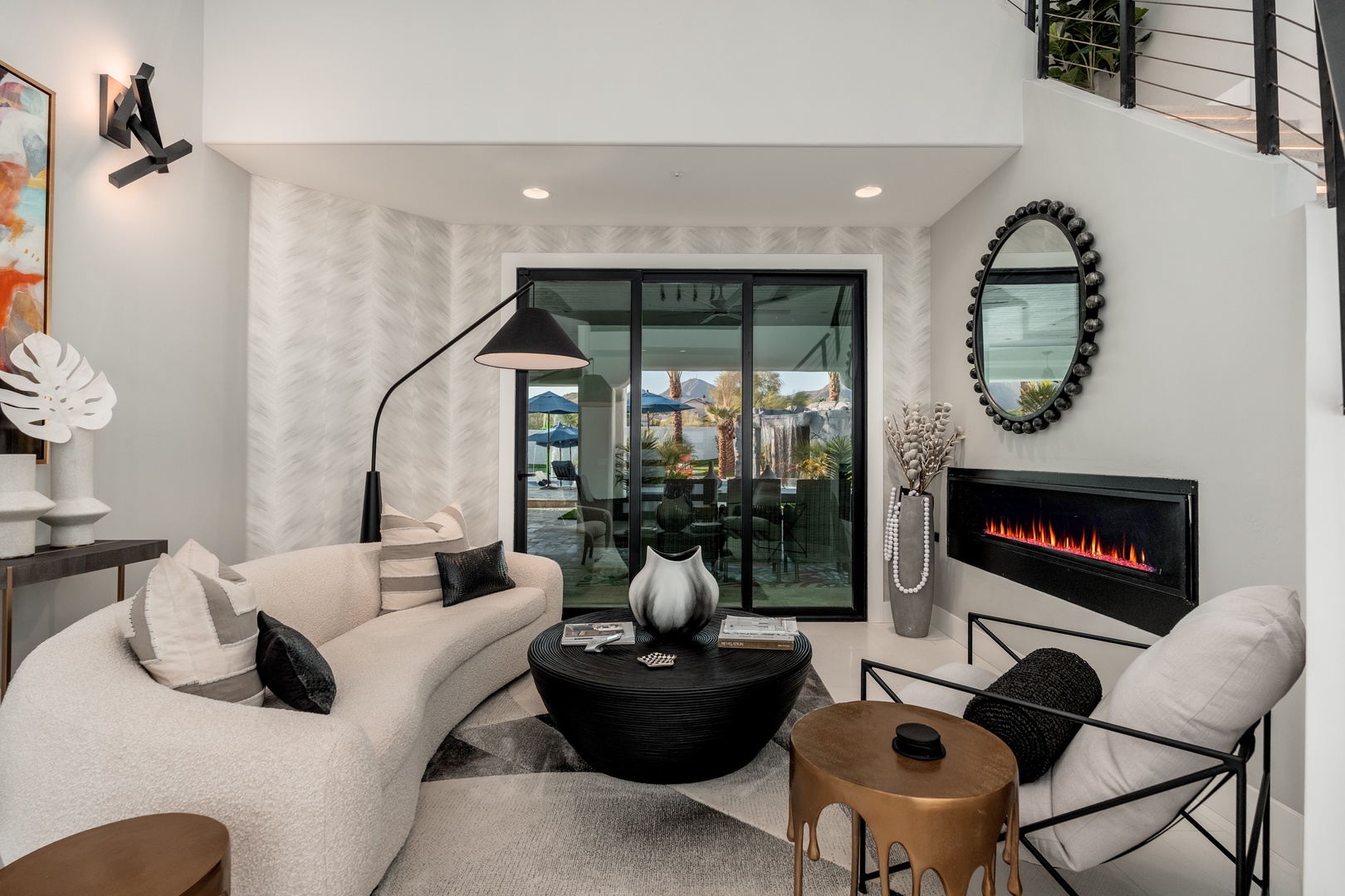 Sink into plush sofas by the modern fireplace in this stylish living space. Natural light pours through sleek glass doors opening to your patio, blending indoor comfort with outdoor ease.