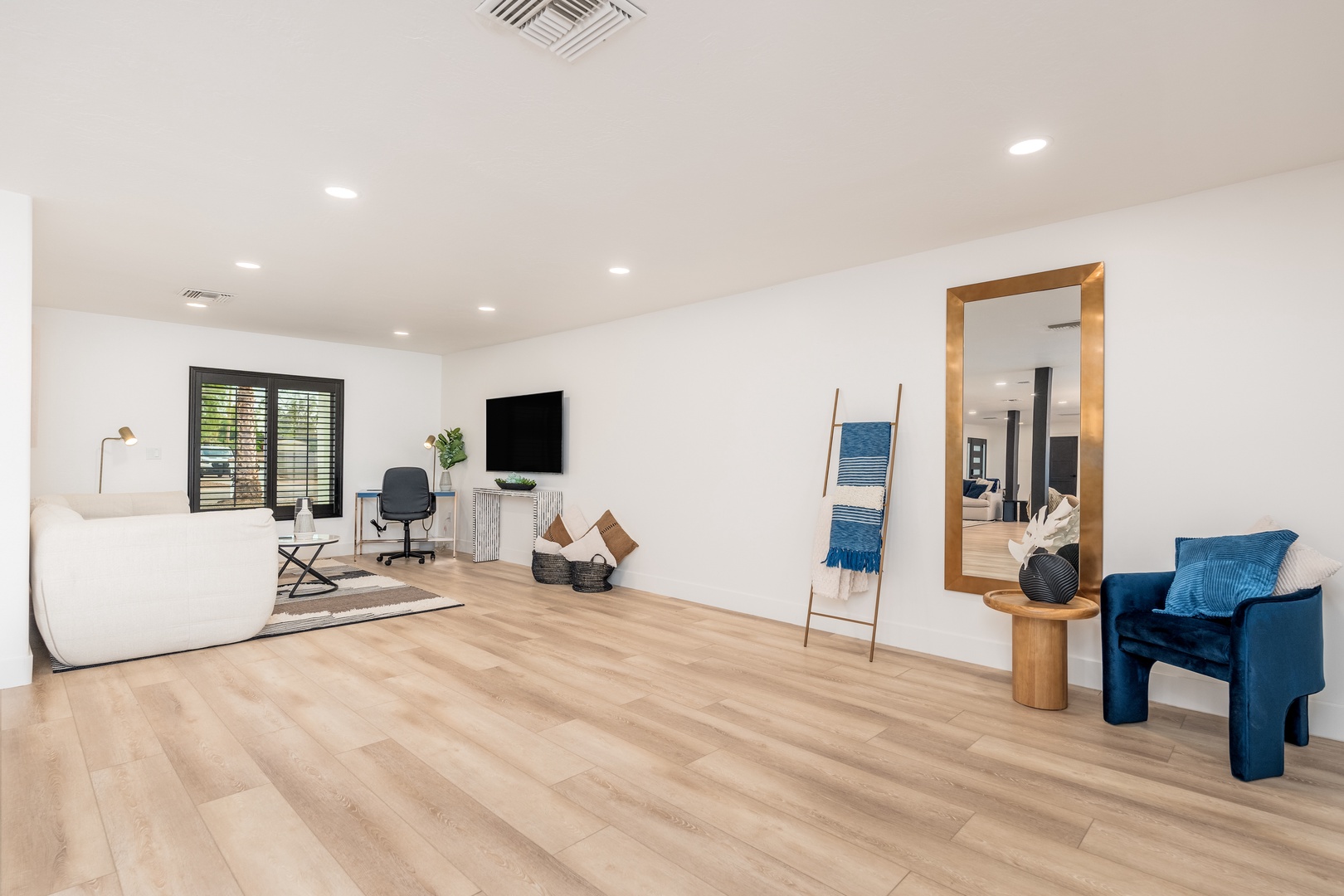 Spacious living area with stylish furnishings, natural light, and a cozy seating arrangement invites you to unwind in comfort and tranquility.