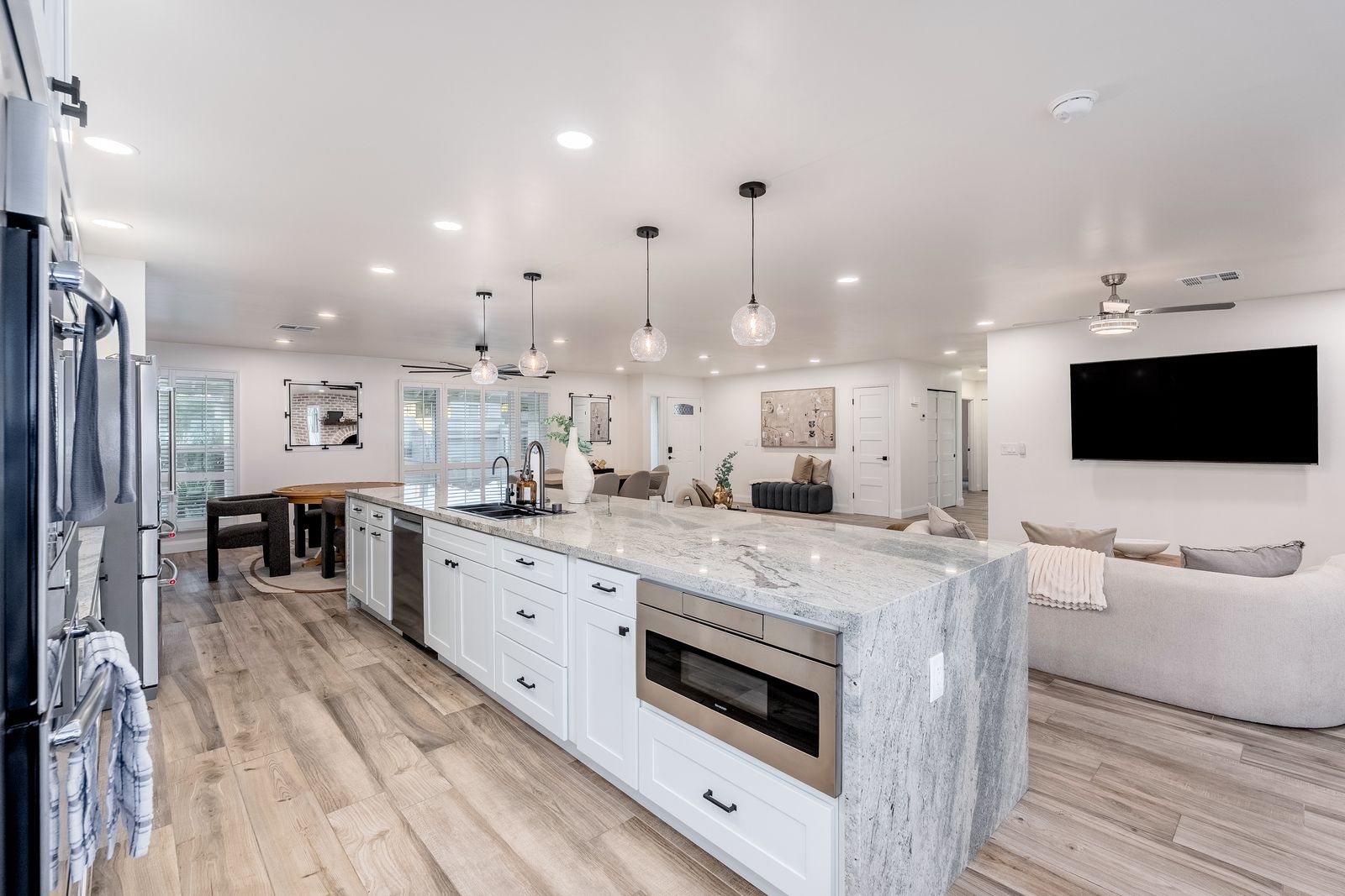 Step into your open-concept haven where the sleek kitchen island flows into the bright living space, inviting you to gather, cook, and unwind in modern comfort.