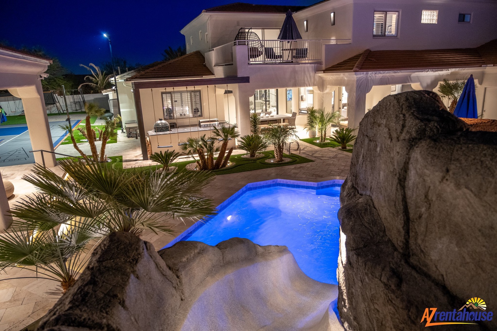 Stunning villa exterior featuring an illuminated swimming pool and elegant architecture at night.