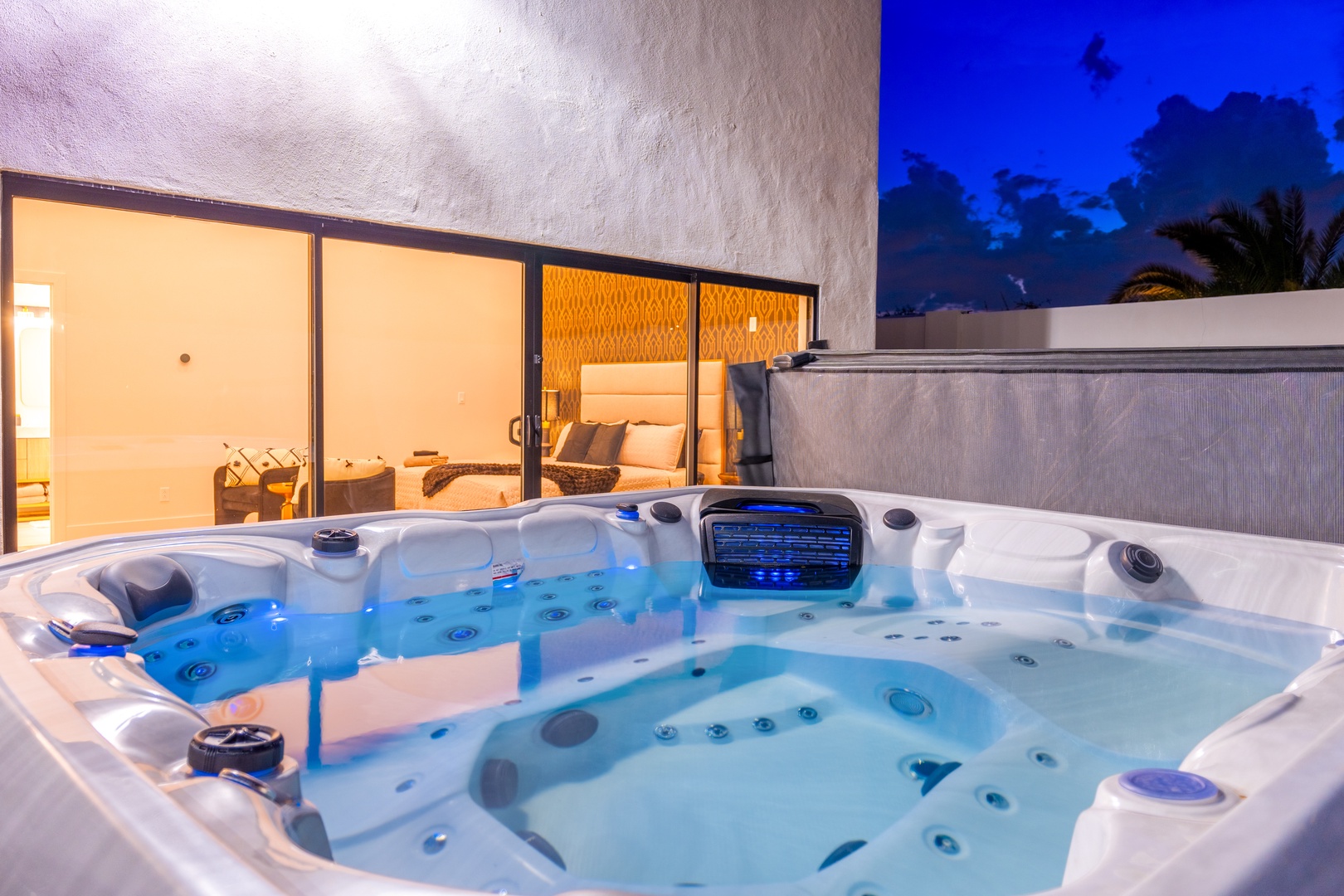 Unwind under the stars in your private hot tub overlooking the glowing bedroom suite. Enjoy twilight soaks with tropical palms swaying above and the gentle warmth of bubbling jets easing away the day.