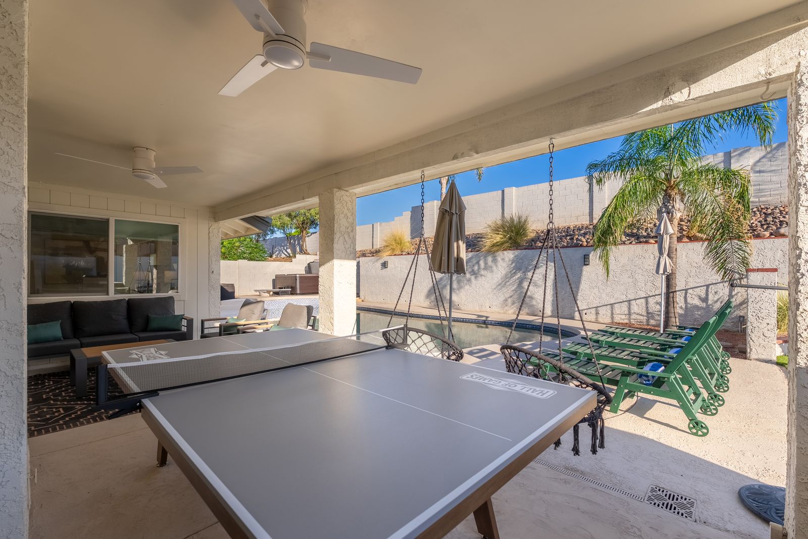 Your own private game room awaits with ping pong and hanging chairs, perfect for lazy afternoons and friendly competition under ceiling fans that keep things cool.