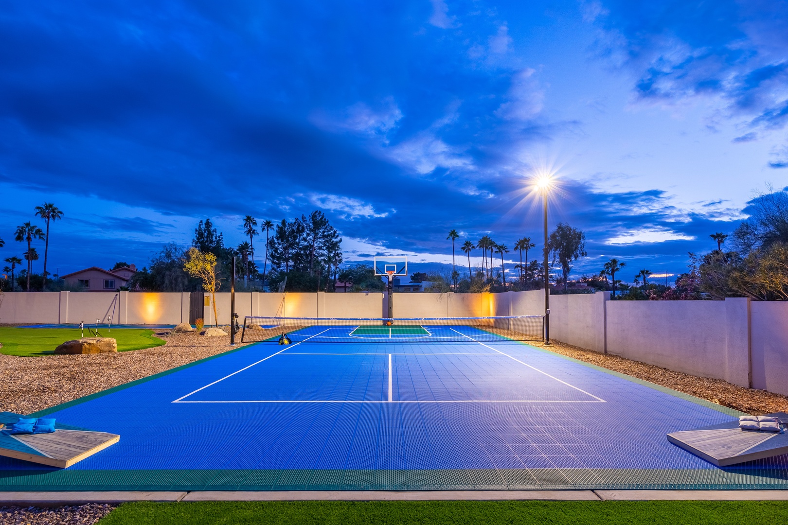 A private sport court set against a twilight sky, framed by palm trees and mountain views—ideal for friendly games and evening recreation.