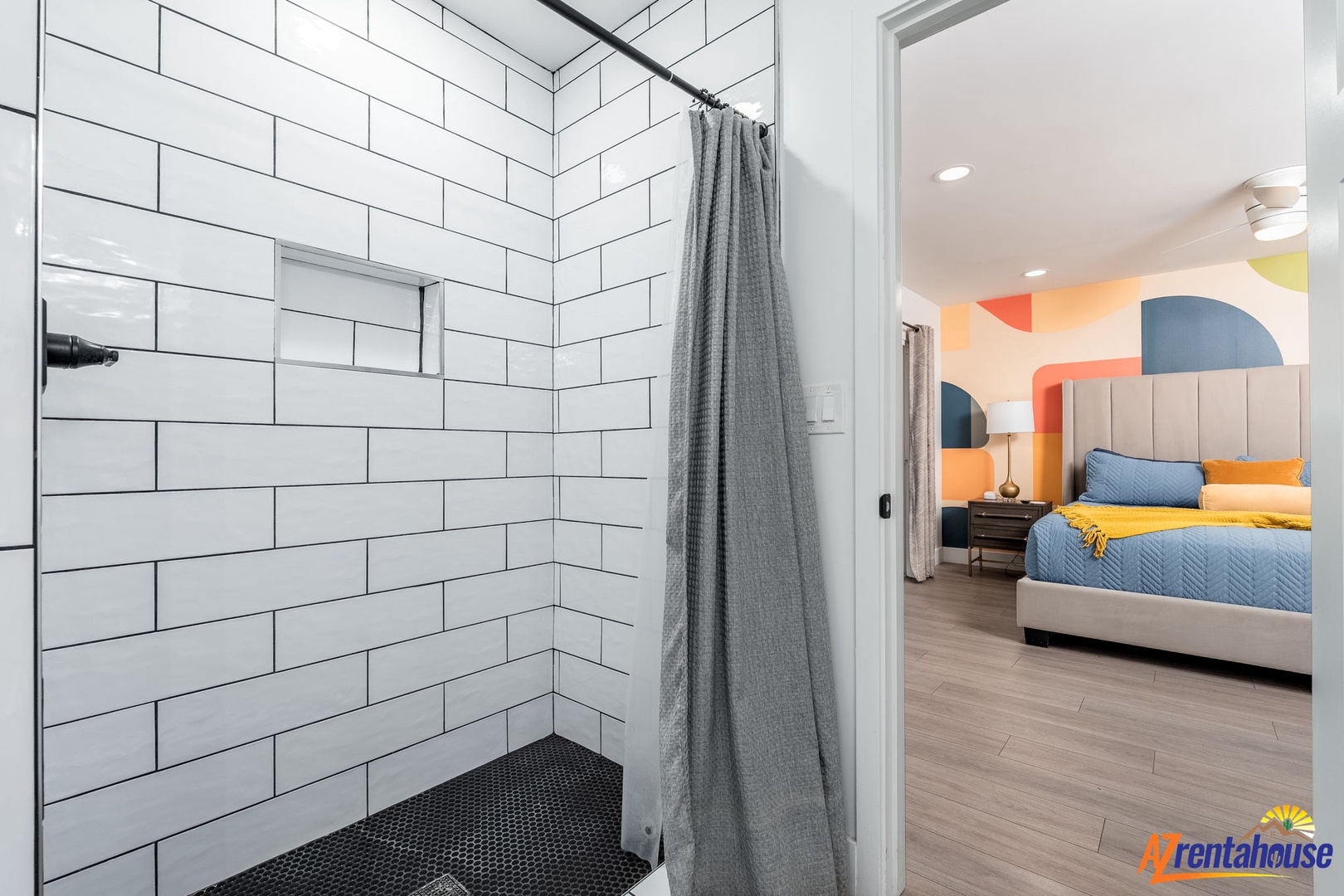 Step into your sleek walk-in shower with modern subway tile, then retreat to your vibrant bedroom sanctuary.