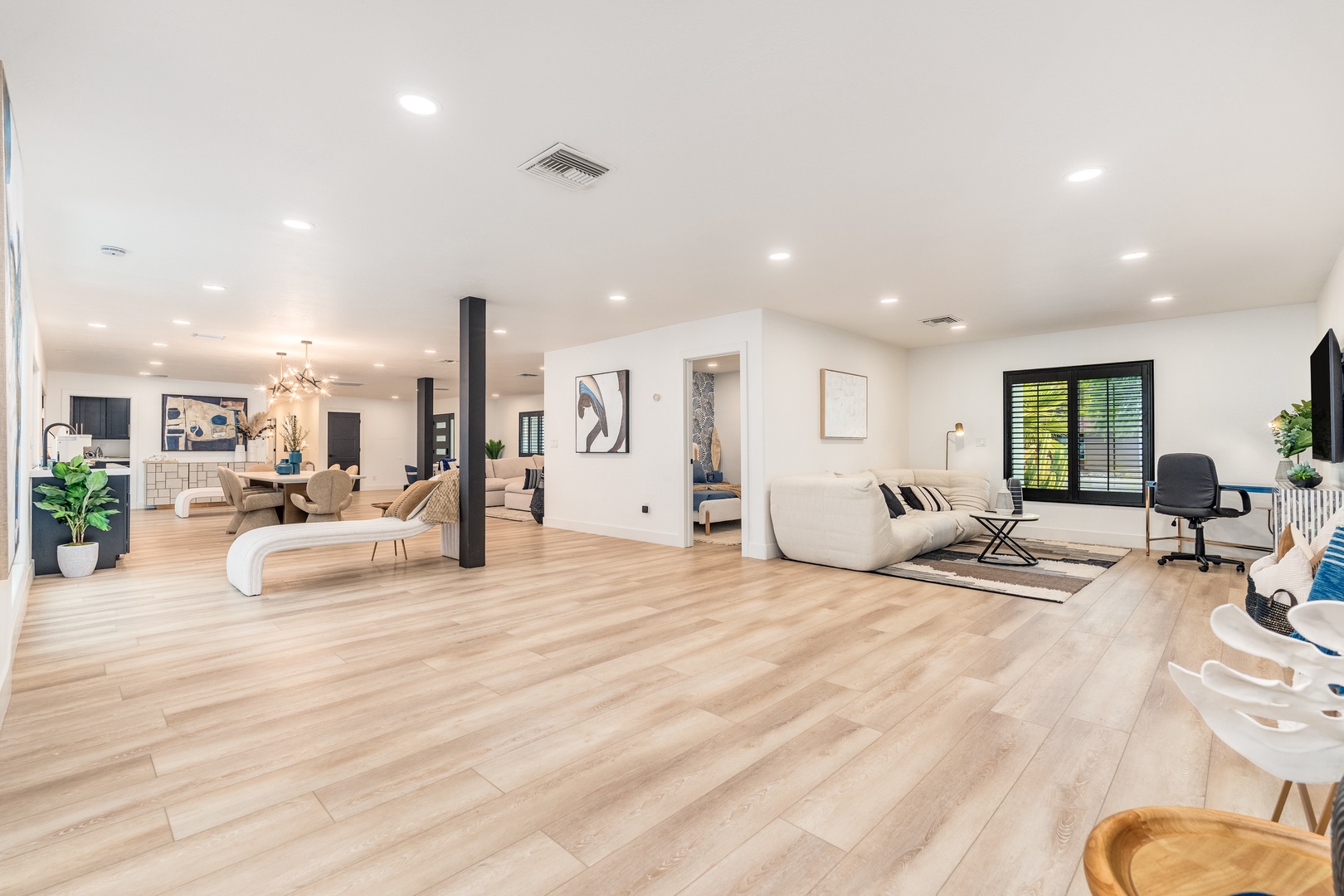 Step inside to discover a beautifully designed open-concept living space where light wood floors and modern décor create a welcoming retreat for your entire group to gather and unwind together.