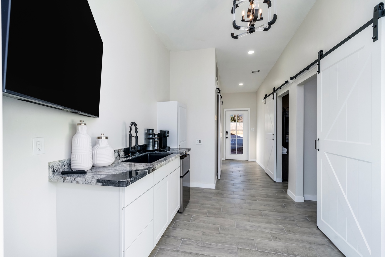 Enjoy your morning coffee in this sleek kitchenette with granite counters, modern appliances, and charming barn doors that add warmth and style to your stay.