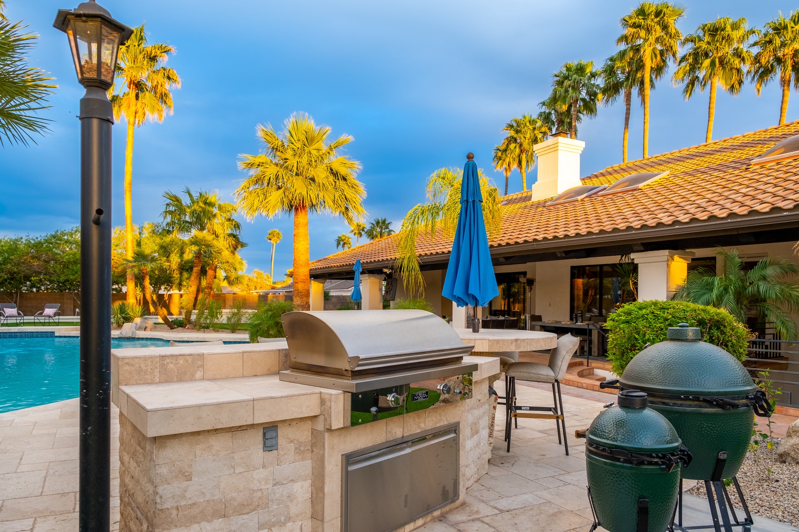Fire up the grill and unwind by the pool—your outdoor kitchen awaits under swaying palms, perfect for sun-soaked cookouts and warm desert evenings.
