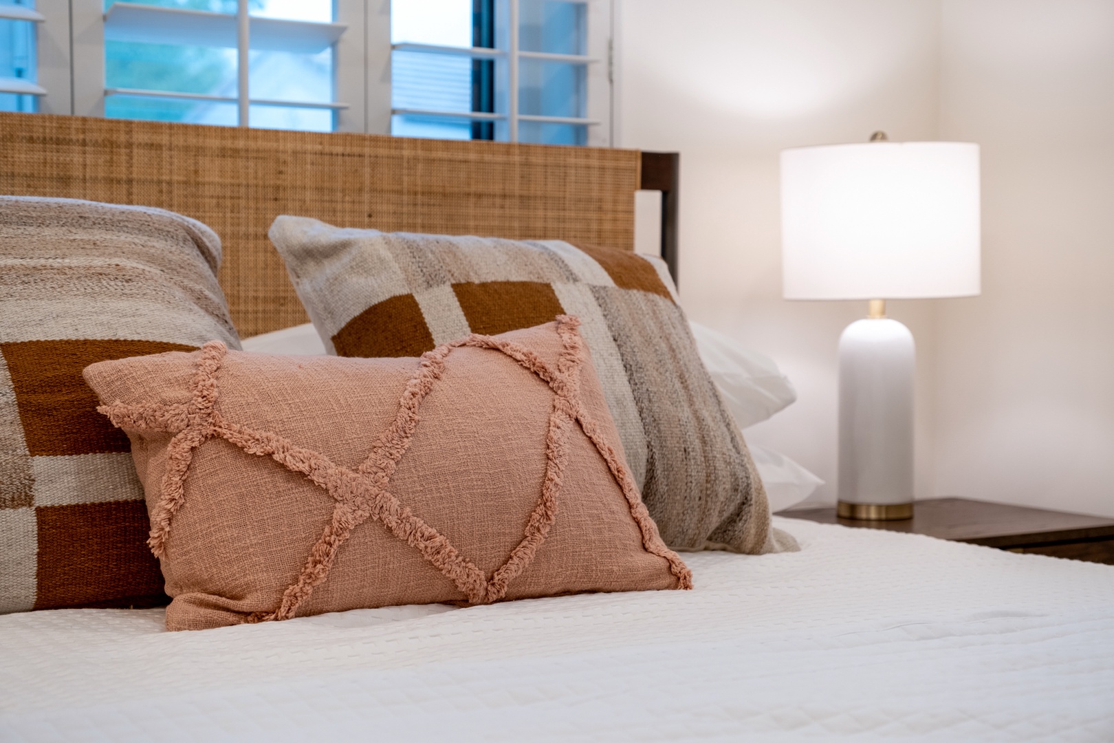 Sink into plush linens and artisan pillows after a day exploring—your serene escape awaits with natural textures and soft lighting welcoming you home.