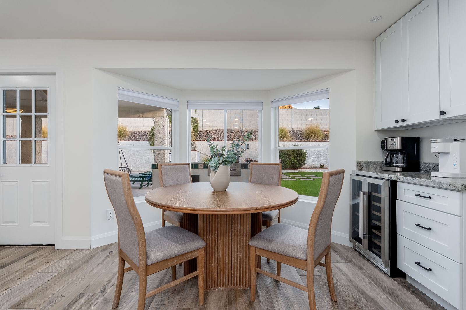 Gather around this inviting round table, where sunlight pours through bay windows and fresh coffee is always within reach. Your mornings here feel effortlessly bright and welcoming.