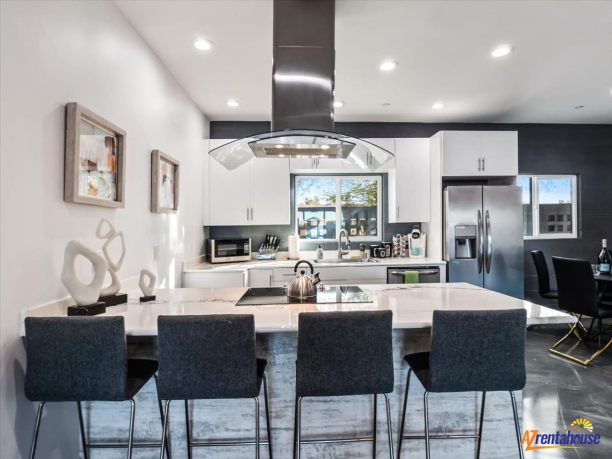 Your sleek modern kitchen awaits with stainless steel appliances, spacious island seating, and everything needed for memorable meals together.