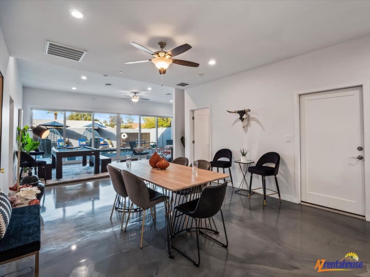 Step into your stylish open living space where polished floors gleam beneath soaring ceilings and natural light pours through expansive windows.