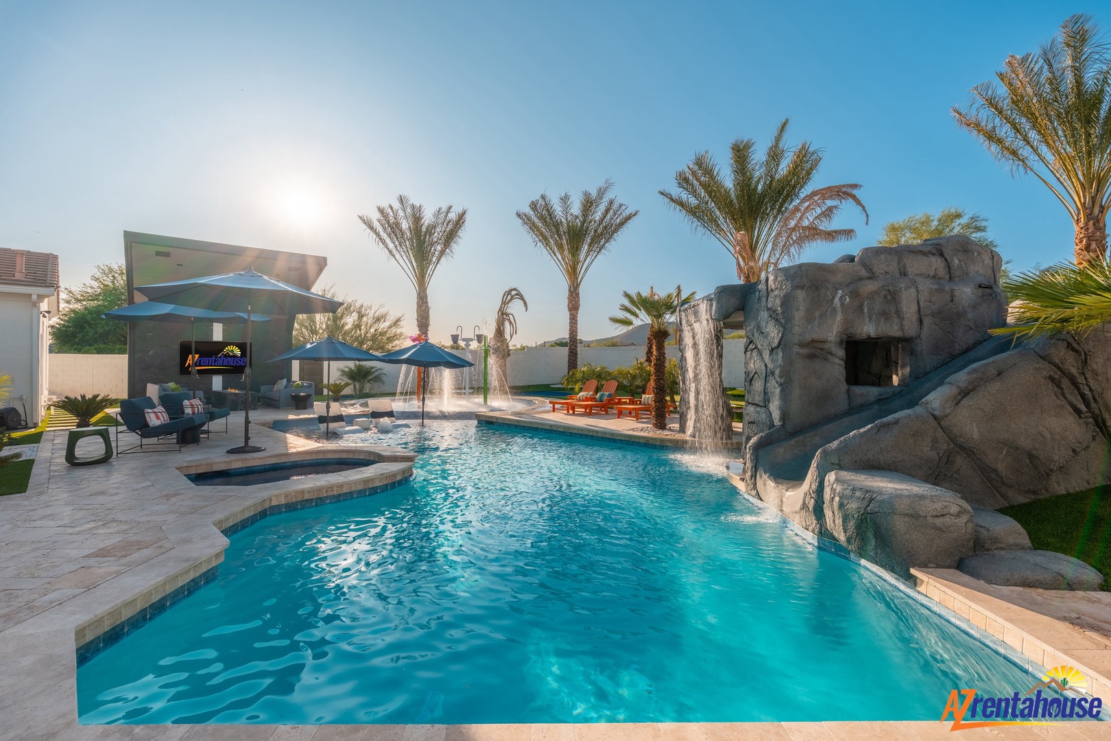 Dive into your private oasis with crystal-clear waters, rock waterslide, and tropical palms creating the perfect desert paradise.