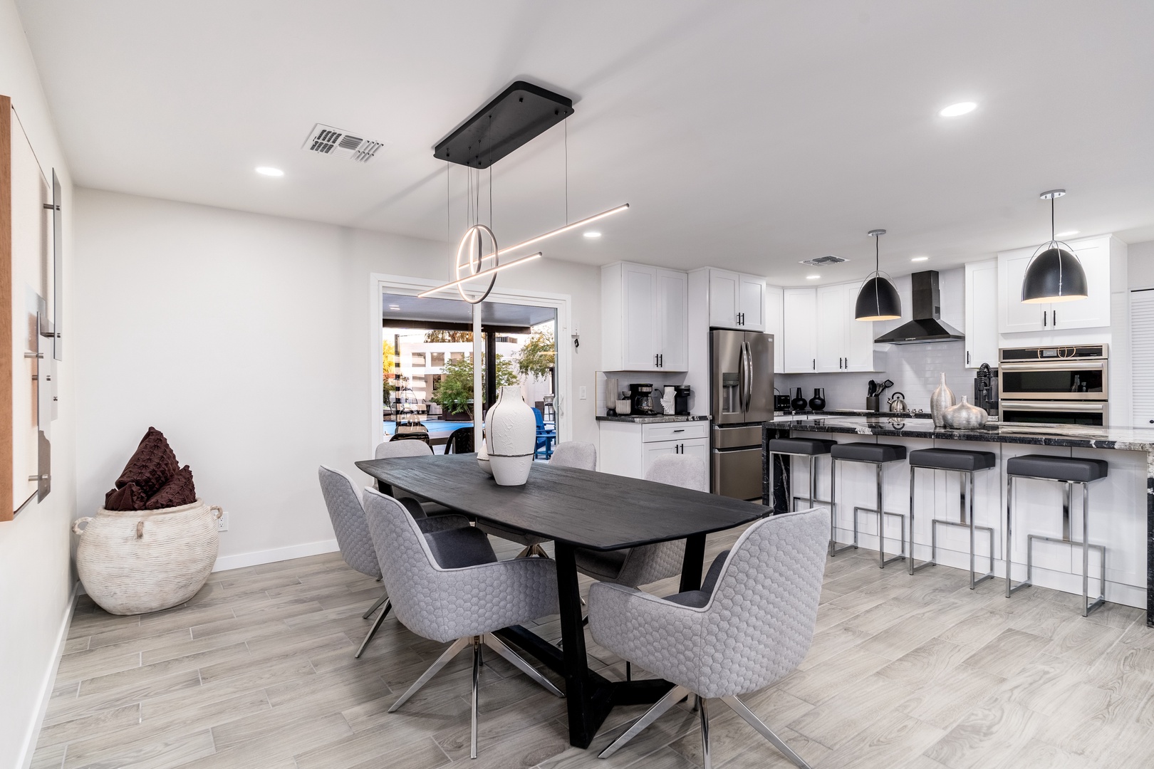 Gather around the sleek dining table or perch at the modern island in your fully equipped kitchen, where stainless steel appliances and bright finishes create an inviting space for meals and memories.