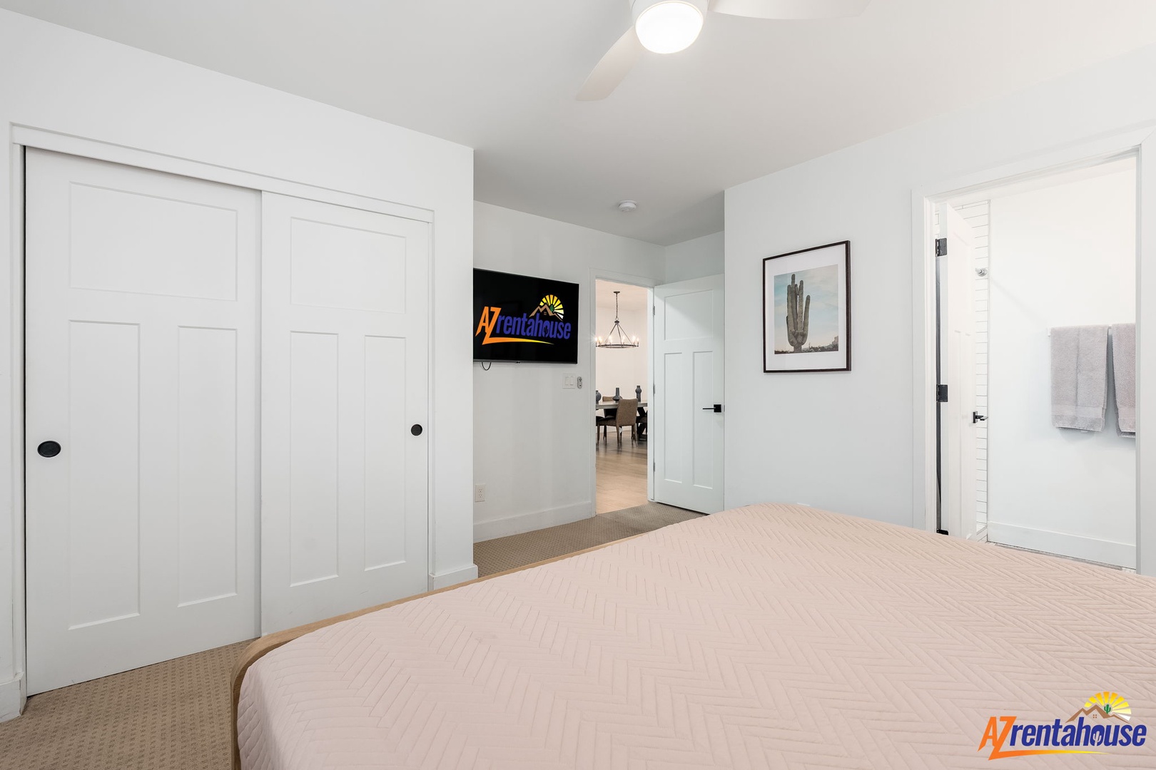 Your modern bedroom features crisp white walls, a wall-mounted TV for entertainment, and direct access to your private en-suite bathroom.