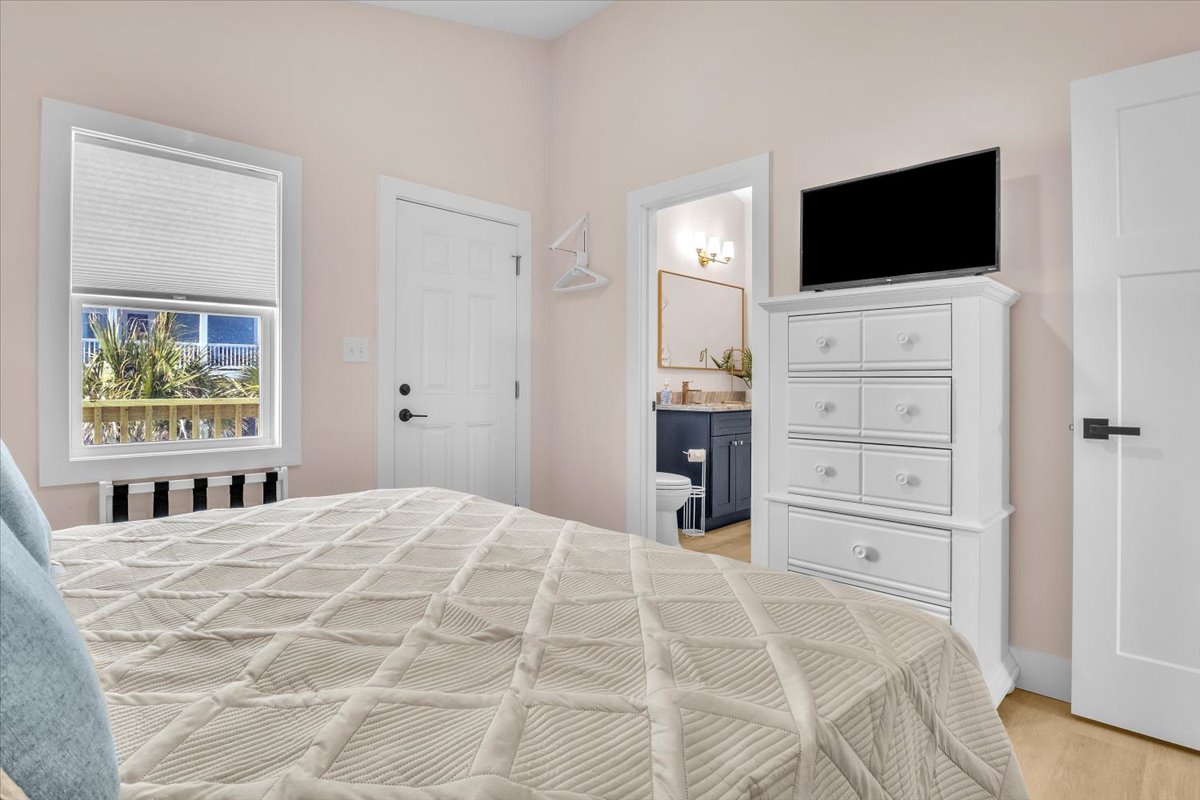 Unwind in your peaceful bedroom featuring a plush bed, flat-screen TV, and ensuite bathroom for complete comfort.