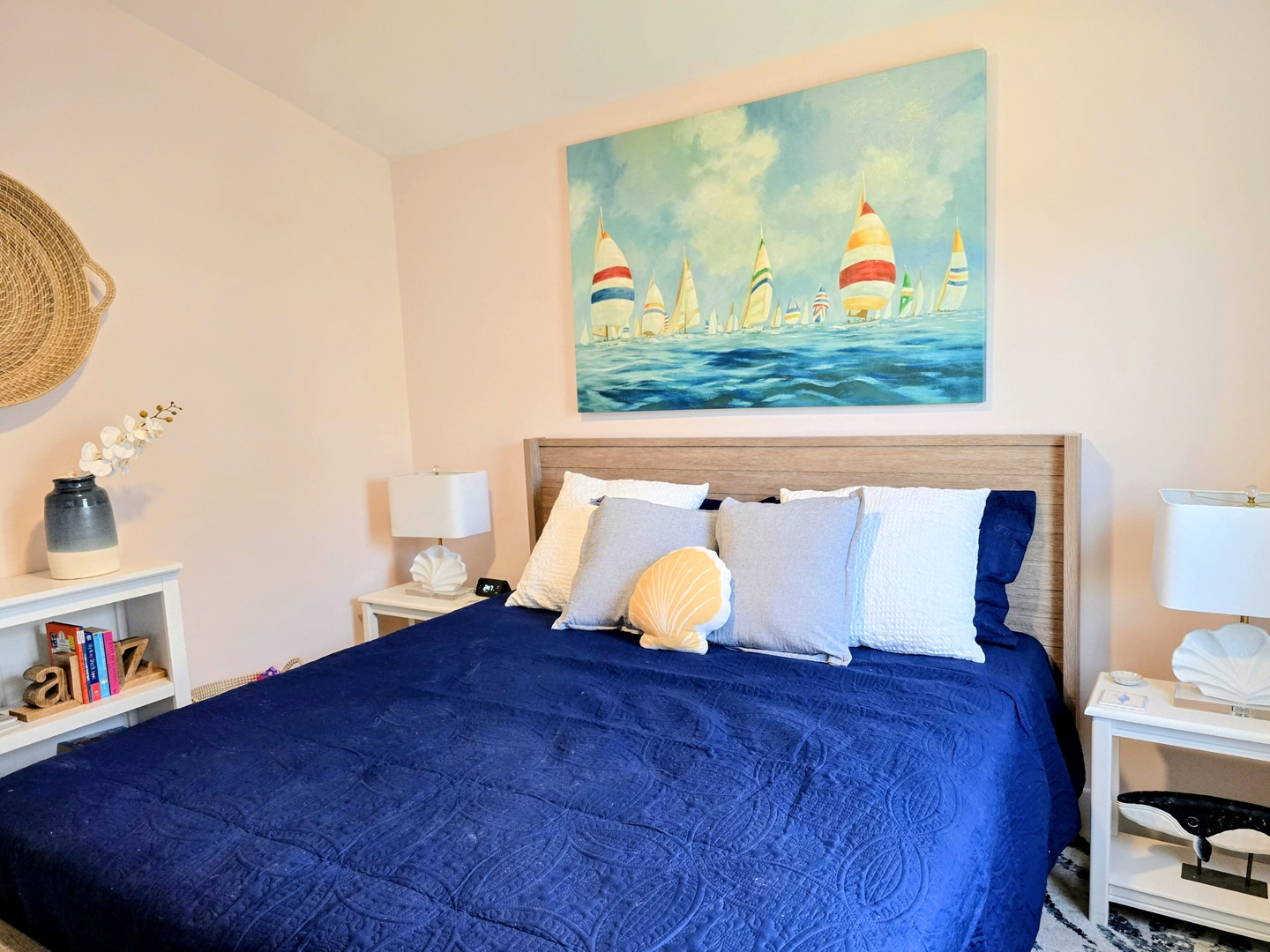 Drift off under nautical artwork in this serene bedroom, where ocean blues and coastal charm create your perfect seaside retreat.