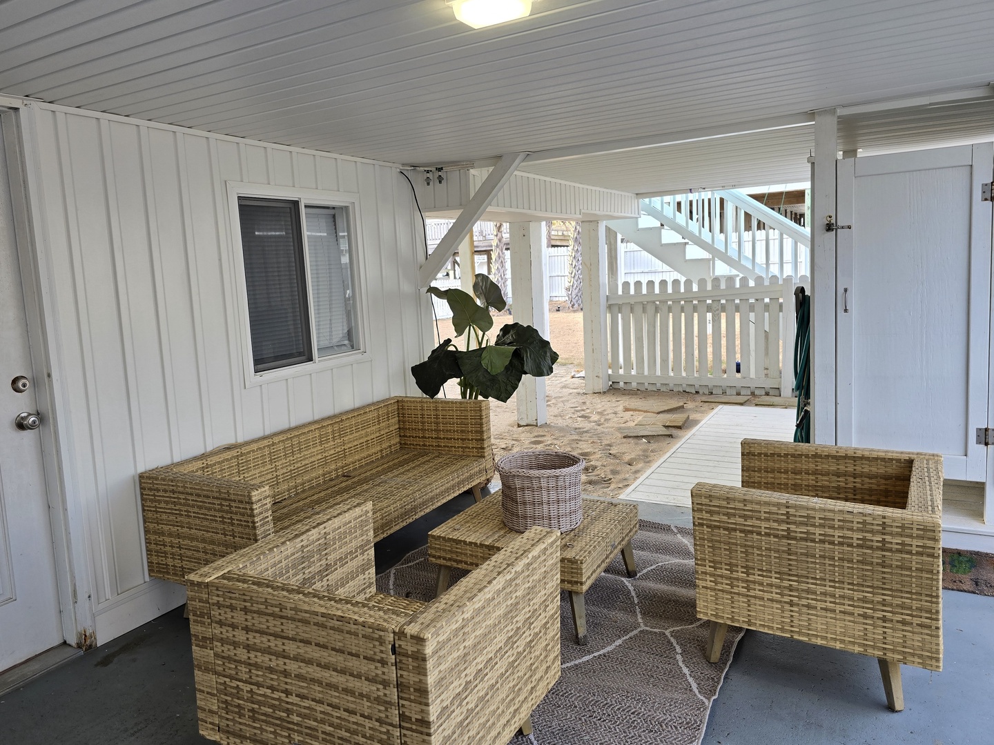 Unwind on your private covered patio with comfortable wicker seating, perfect for morning coffee or evening relaxation.