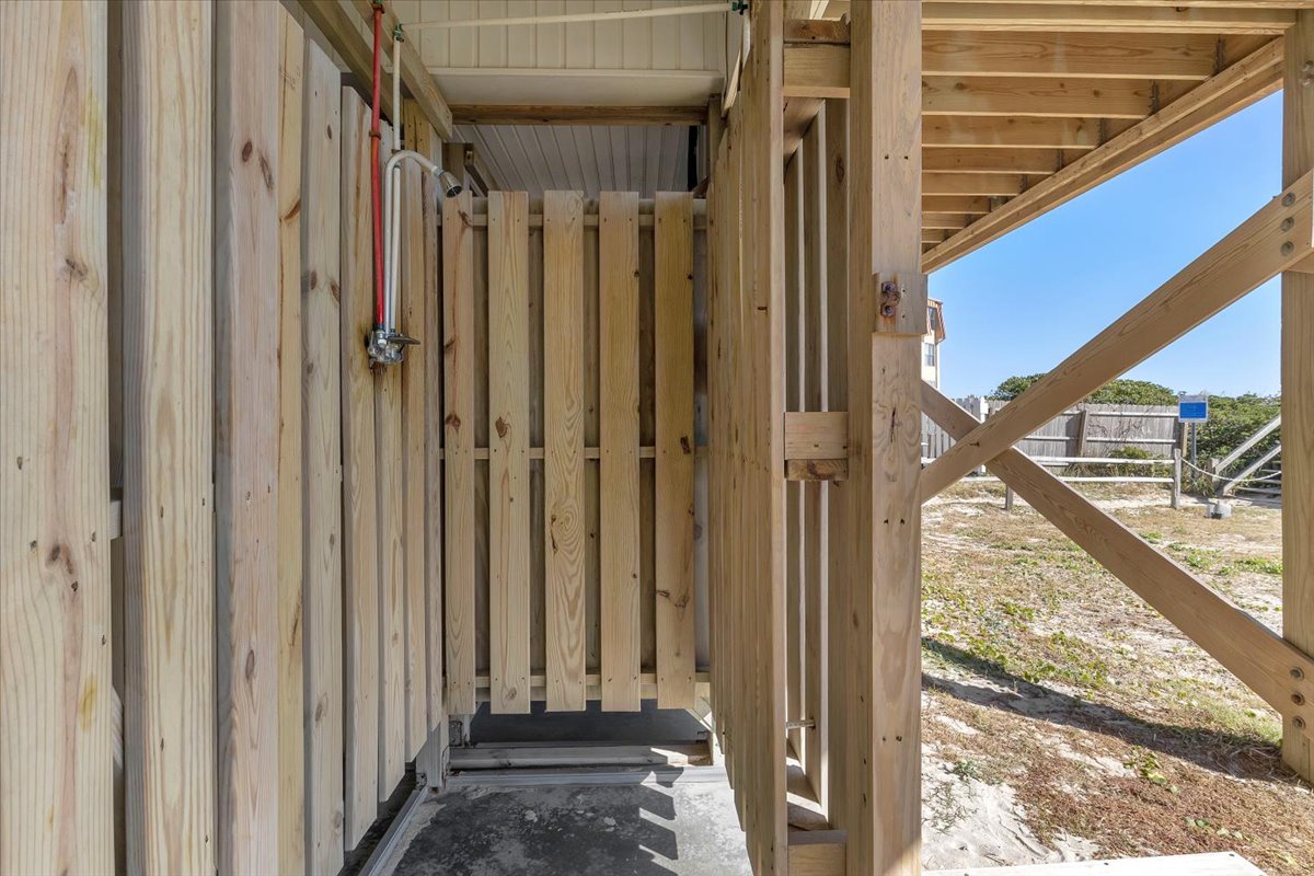 Your private outdoor shower with natural wood privacy screens offers a refreshing way to rinse off salt and sand after beach days.