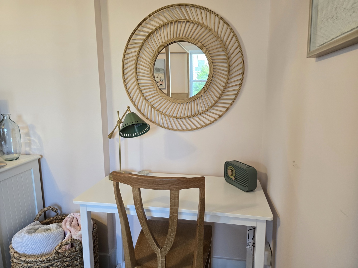Your elegant workspace features a stunning gold sunburst mirror and stylish lamp, creating the perfect spot for morning coffee or evening journaling.
