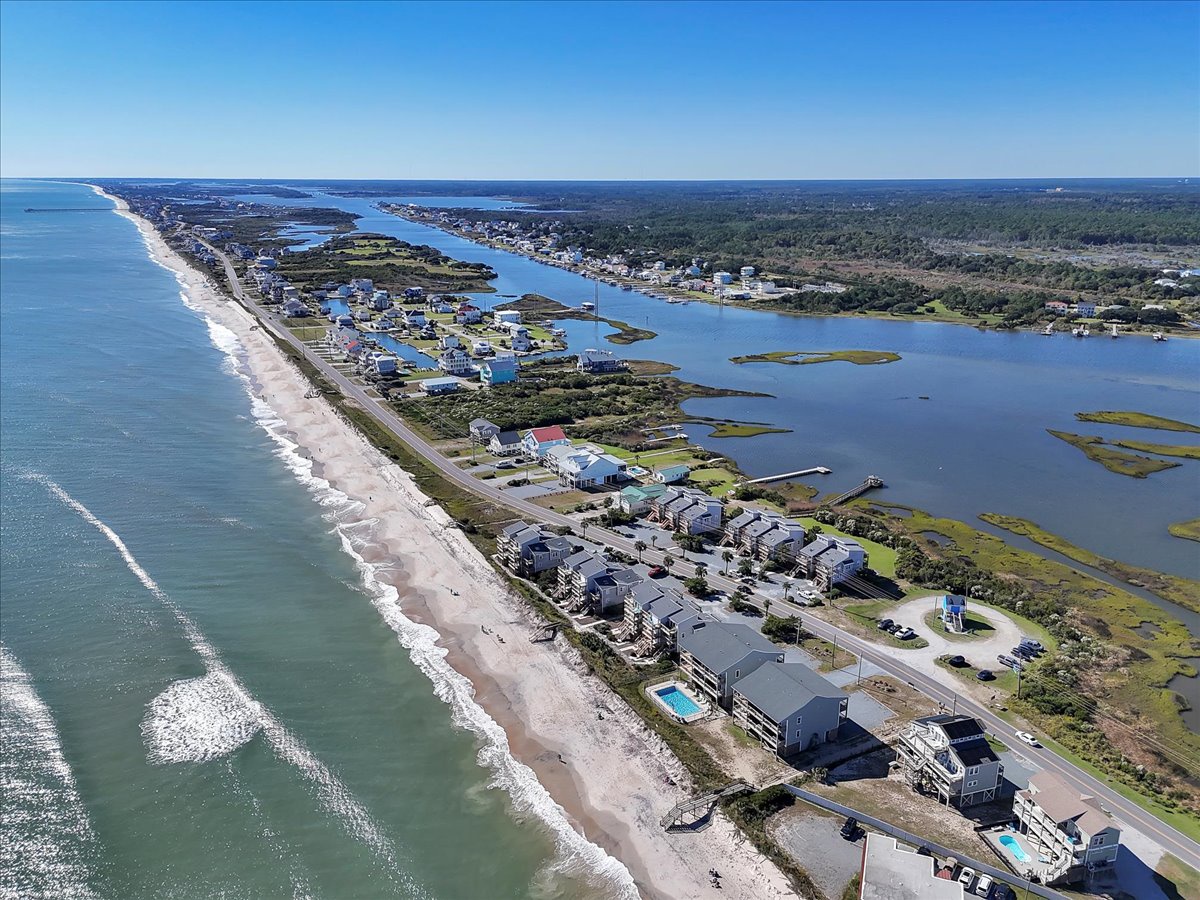 Stunning aerial perspective of a pristine coastal community featuring oceanfront homes, pristine beach access, and scenic waterway views.