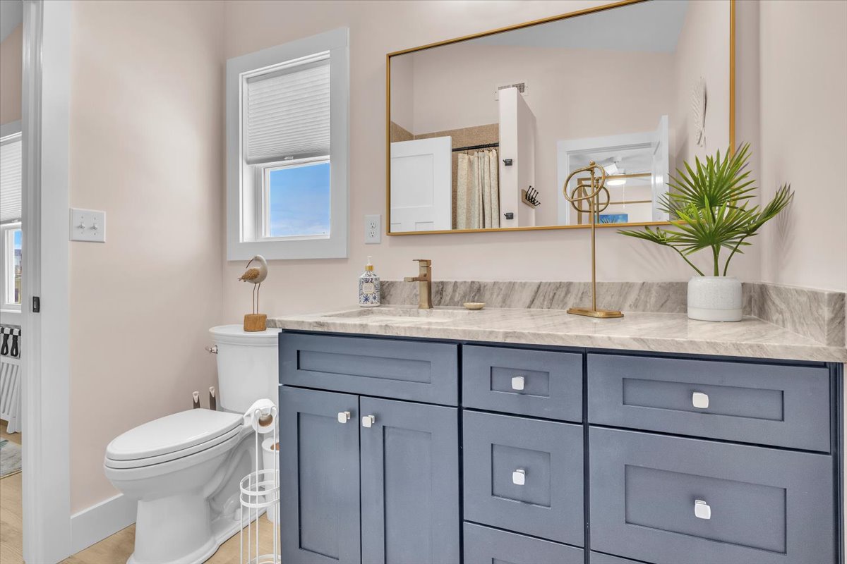 Unwind in your stylish bathroom featuring elegant marble countertops, thoughtful blue cabinetry, and golden brass accents that create a spa-like retreat for your daily routines.