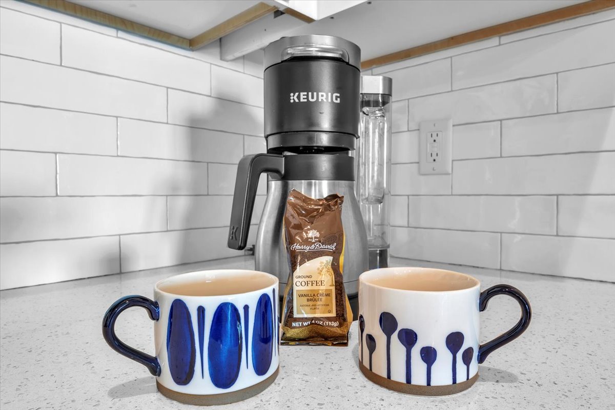 Start your morning right with a premium Keurig coffee maker and artisan mugs, ready to brew your perfect cup in this well-appointed kitchen.