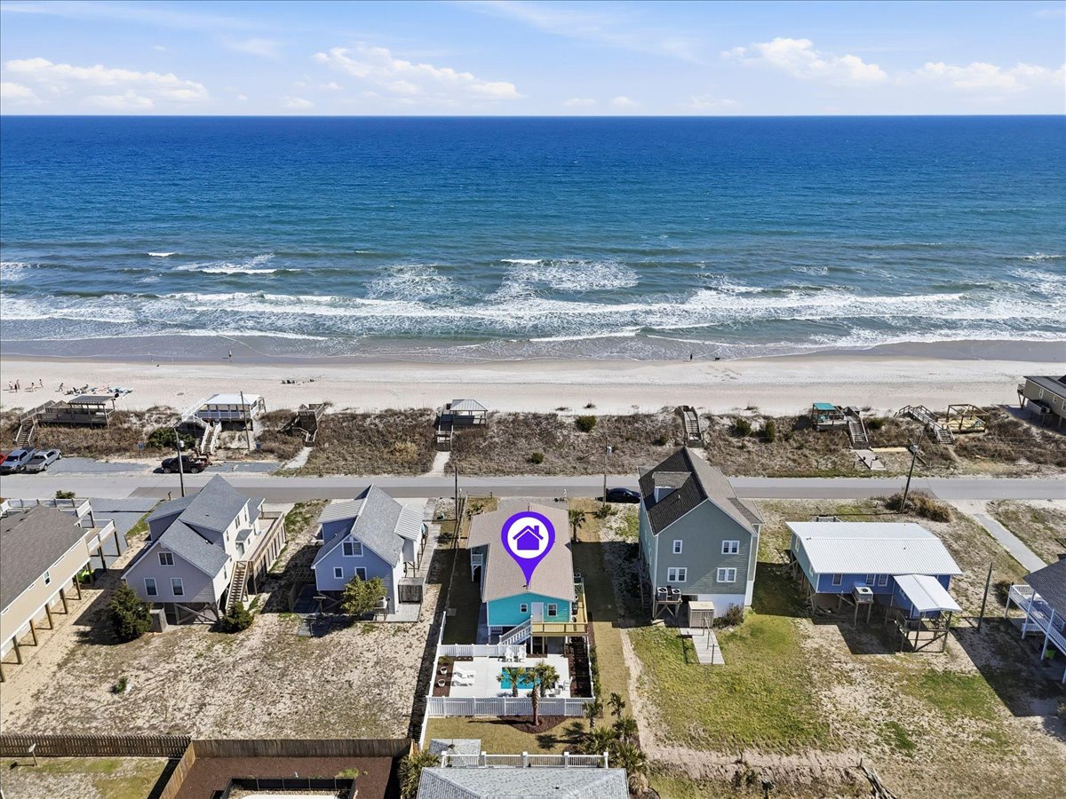 Aerial view of beachfront vacation rental property marked with purple pin, showcasing prime oceanfront location with direct beach access and private pool.