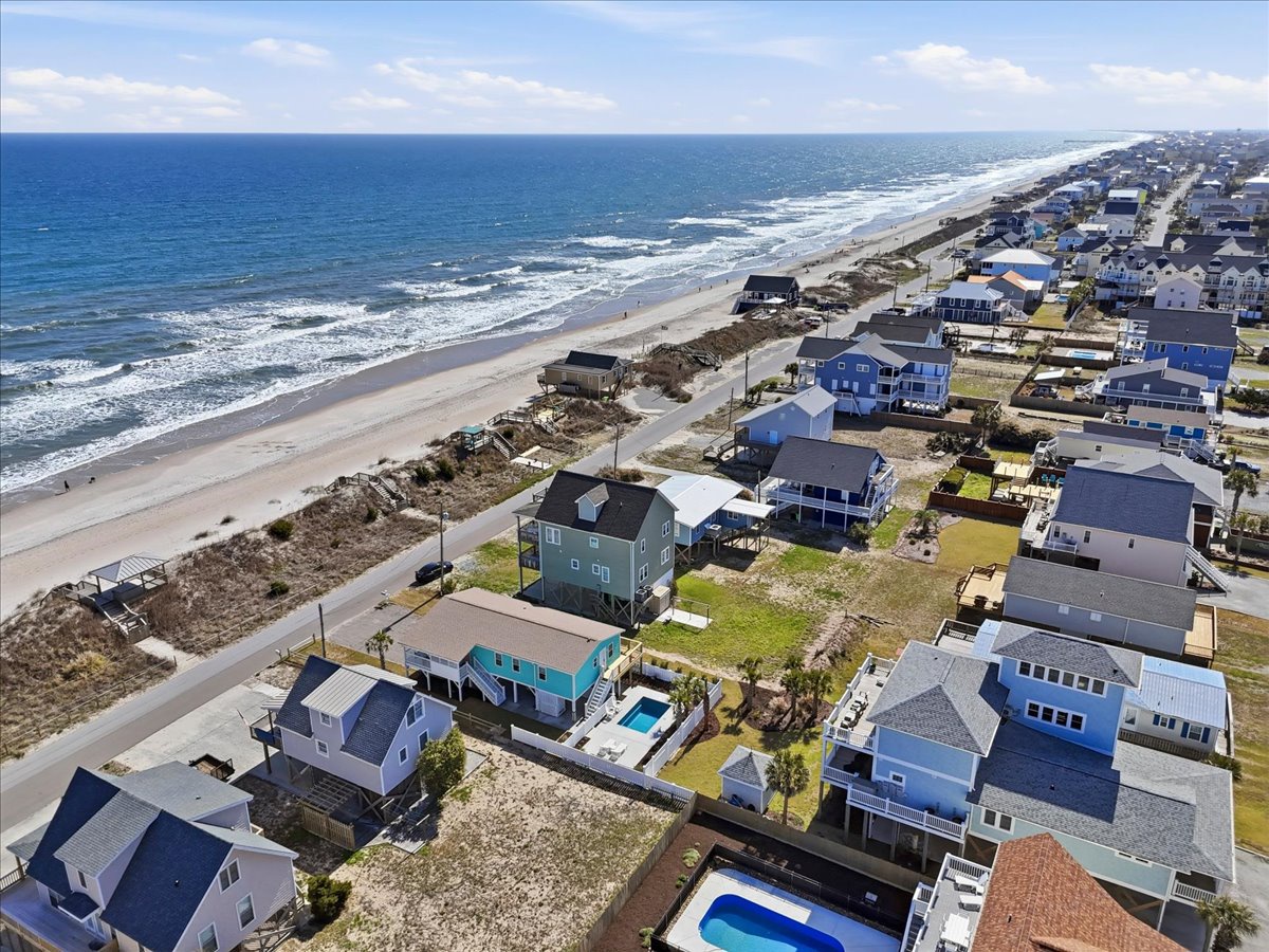 Stunning beachfront community with colorful homes and pristine coastline stretching along the shore.