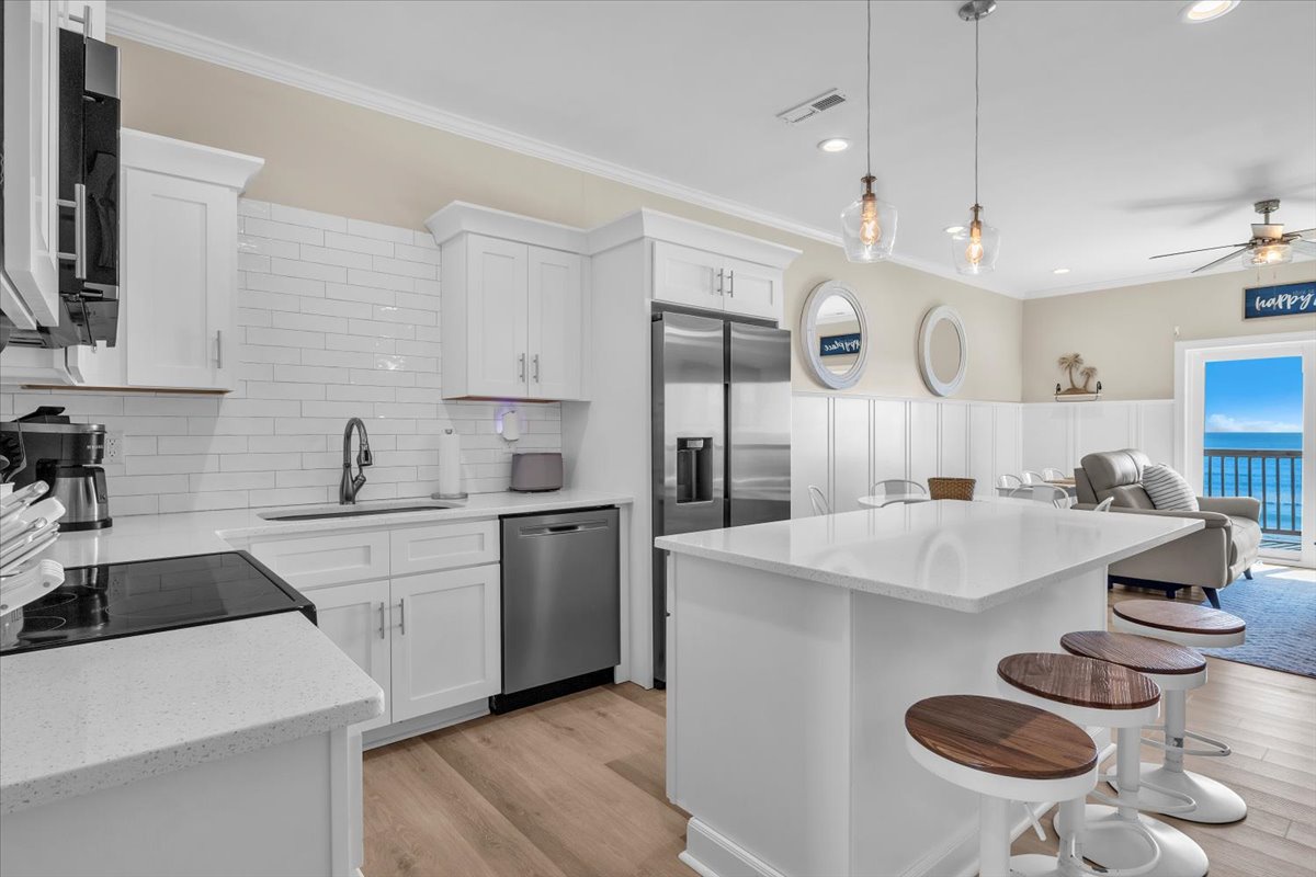 Your sleek white kitchen features modern appliances and a spacious island perfect for morning coffee or evening meal prep.