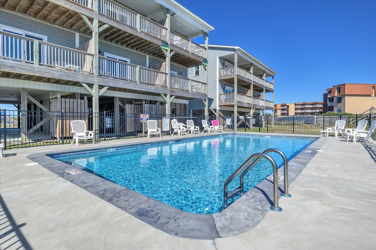 Sparkling pool area with comfortable lounge chairs where you can soak up the sun and unwind after beach adventures.