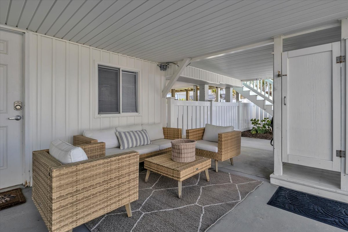 Unwind on your private covered patio featuring comfortable wicker seating and peaceful vibes—perfect for morning coffee or evening relaxation.