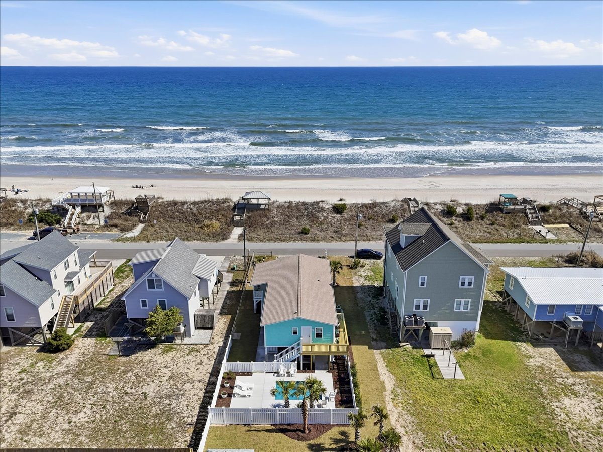 Beachfront vacation homes positioned steps from pristine sandy shores and rolling ocean waves.