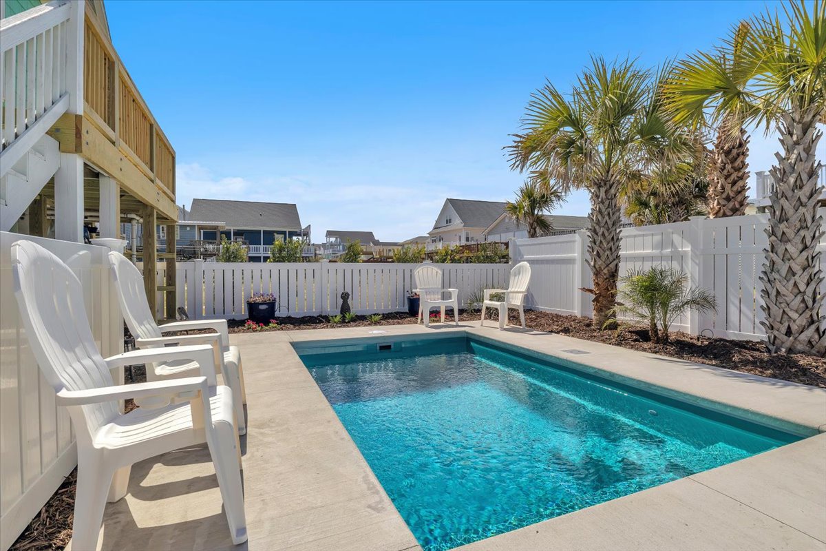 Dive into your own private oasis with sparkling pool, tropical palms, and cozy seating for perfect relaxation.