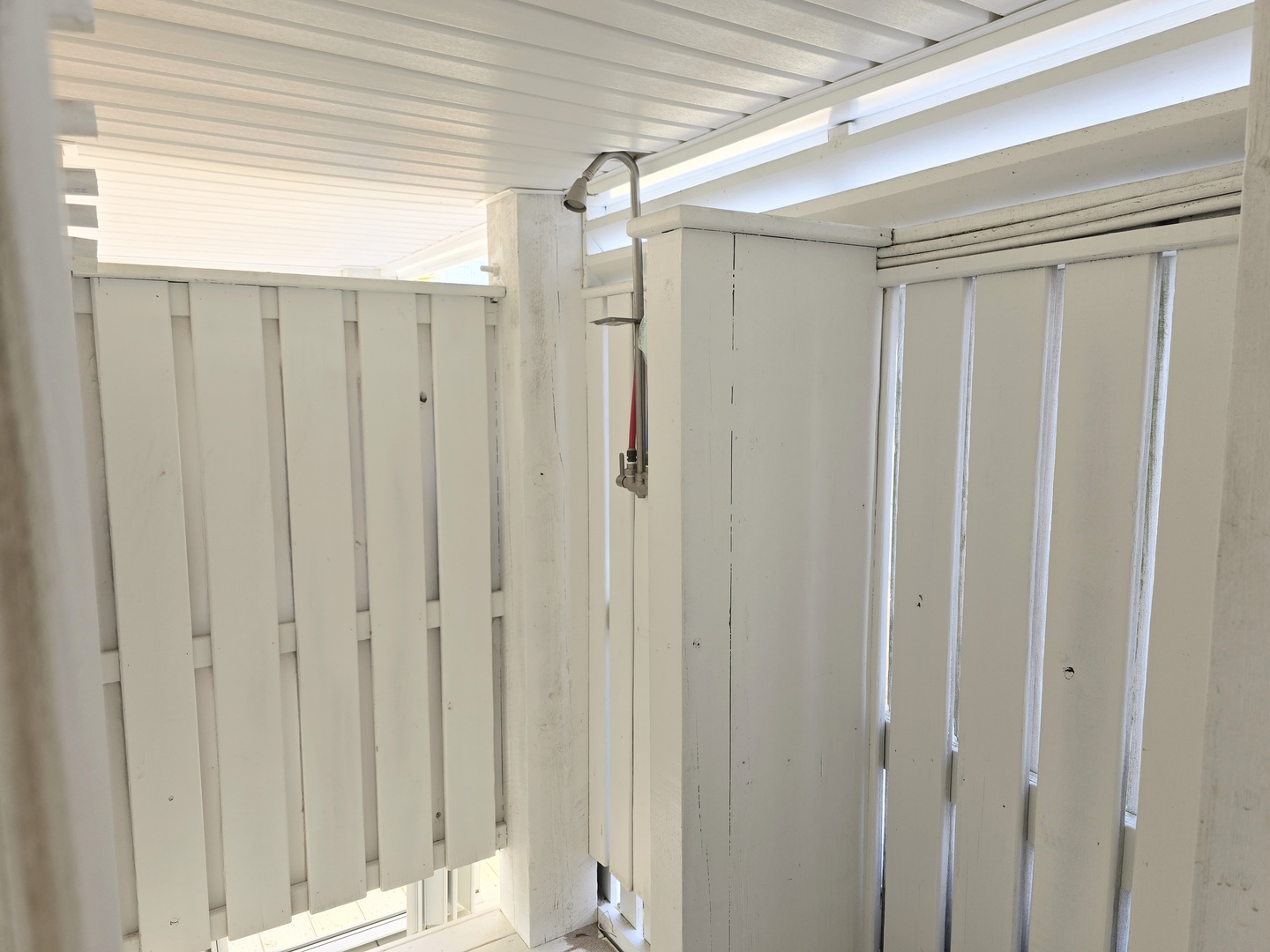 Rinse off in your private outdoor shower space, where white-washed walls create a coastal sanctuary under the open sky.