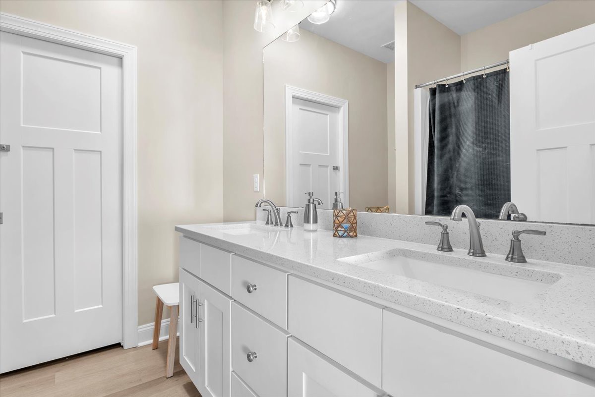 Your pristine bathroom features dual vanities with elegant quartz countertops, perfect for your morning routine together.