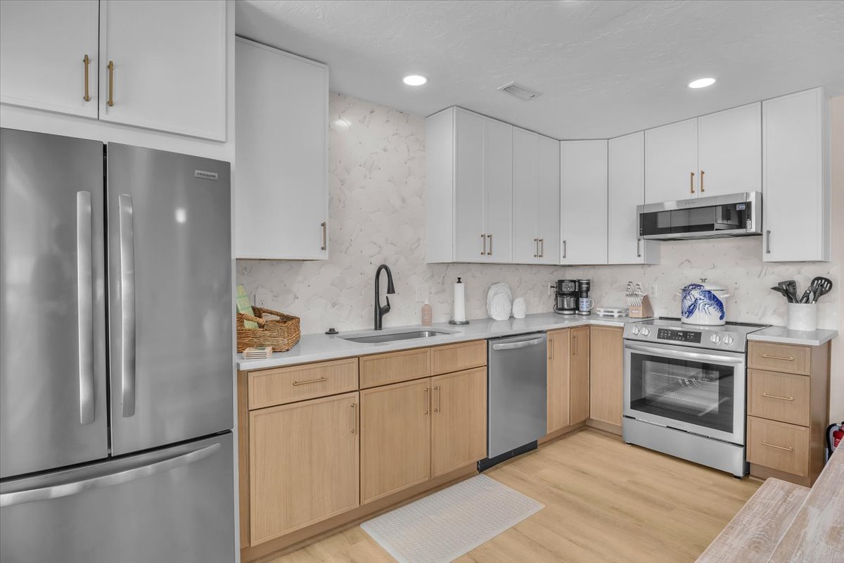 Step into your modern culinary haven with sleek stainless steel appliances and warm wood accents, perfect for crafting meals.