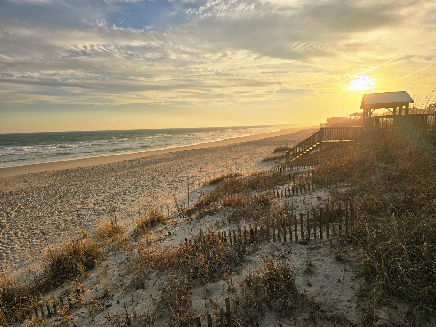 Stunning beachfront location with golden sunrise views over pristine sandy shores and protected dunes.
