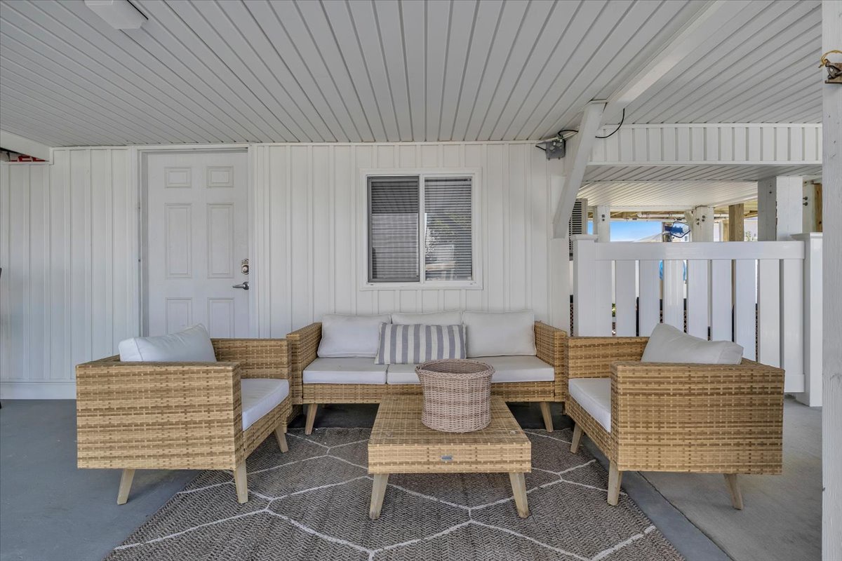 Settle into your private covered terrace with stylish wicker seating, perfect for morning coffee or evening conversations in comfort.