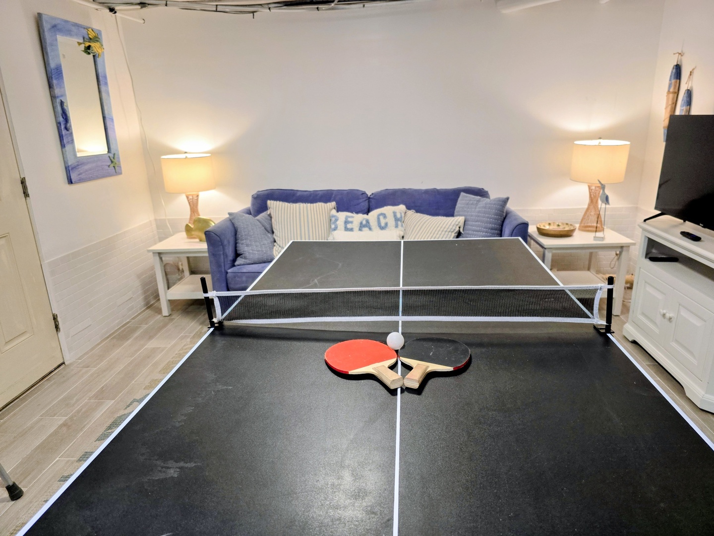 Game on! Your private ping pong table awaits in this cozy living space with coastal charm.