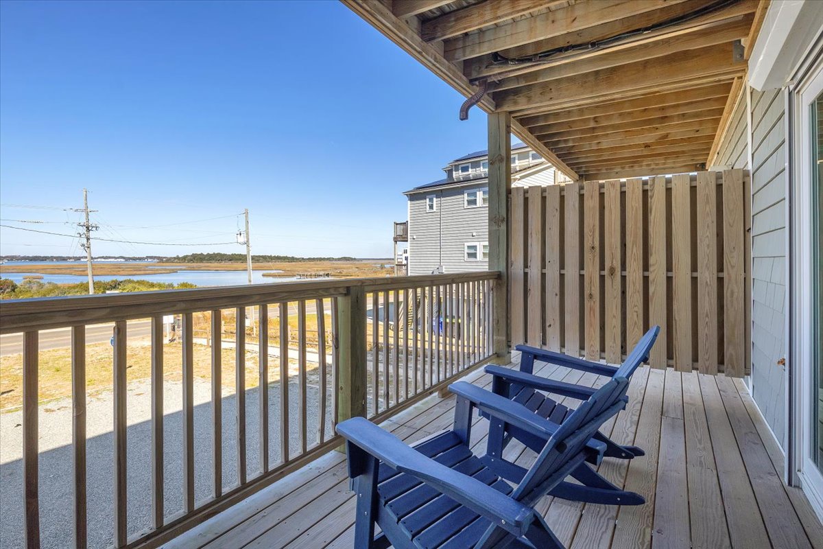 Relax in blue Adirondack chairs while taking in sweeping views of coastal marshlands and water from your private deck.