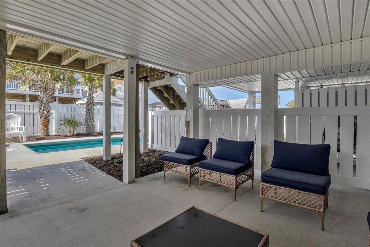 Relax in your private covered patio with comfortable seating while enjoying pool views and tropical landscaping in this peaceful outdoor retreat.