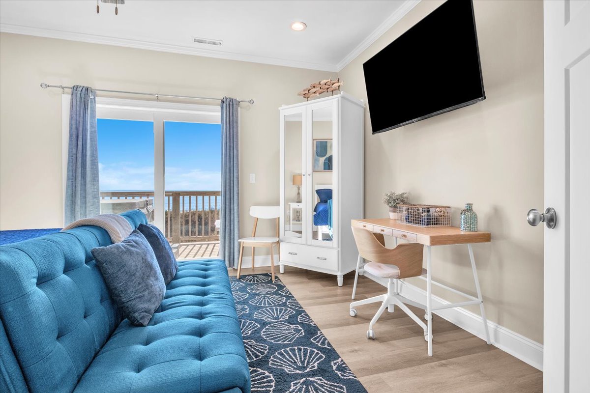 Unwind on your tufted teal sofa while enjoying ocean views through sliding doors to your private balcony.