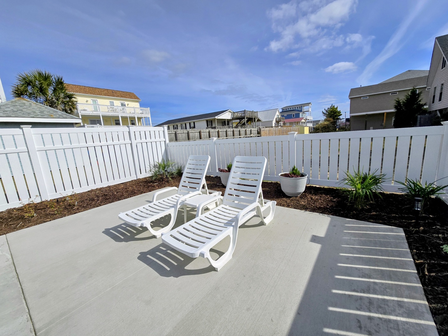 Soak up the sun on your private patio with comfortable lounge chairs and fresh landscaping for perfect relaxation.