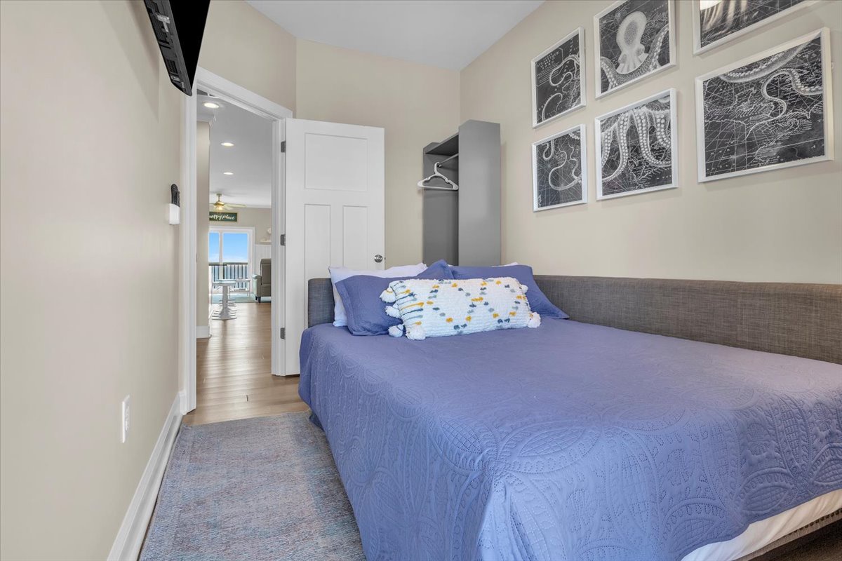 Drift off in your cozy bedroom, where maritime artwork and soft blue linens create a peaceful coastal retreat.