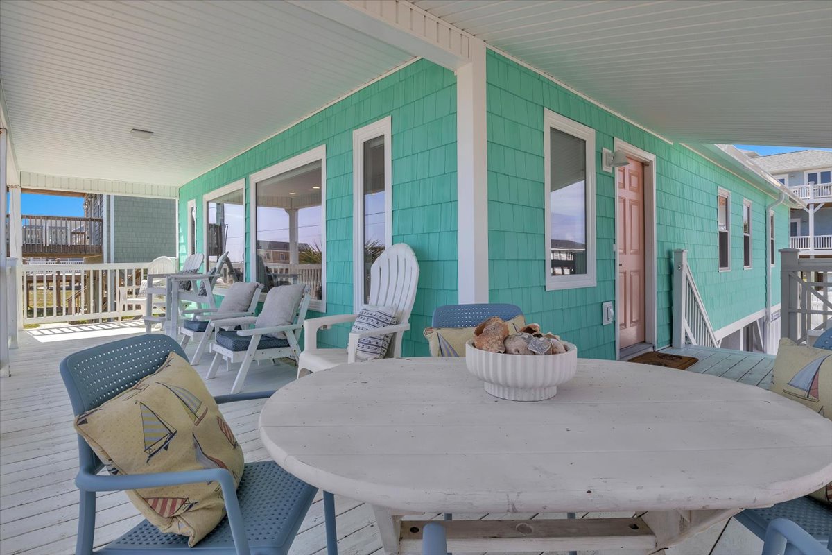Relax on your private covered deck with coastal charm, featuring outdoor dining and lounge seating perfect for morning coffee or sunset cocktails.