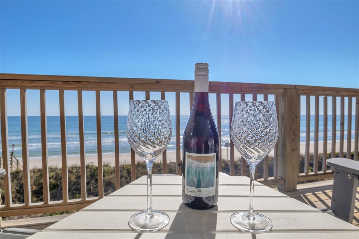 Sip wine on your private balcony overlooking pristine beach views, where crystal glasses catch the ocean breeze and endless horizons create perfect moments.