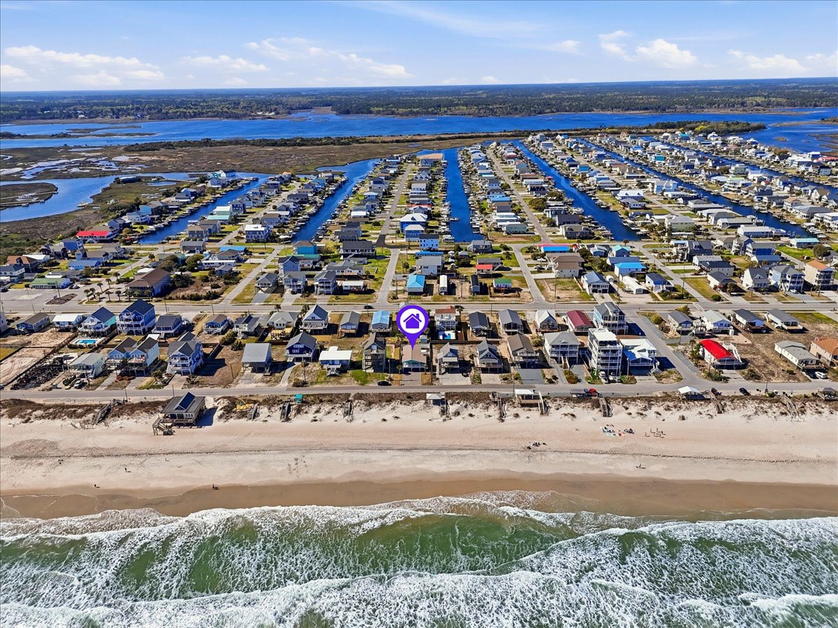 Aerial view of beachfront community with direct ocean access and nearby waterways.