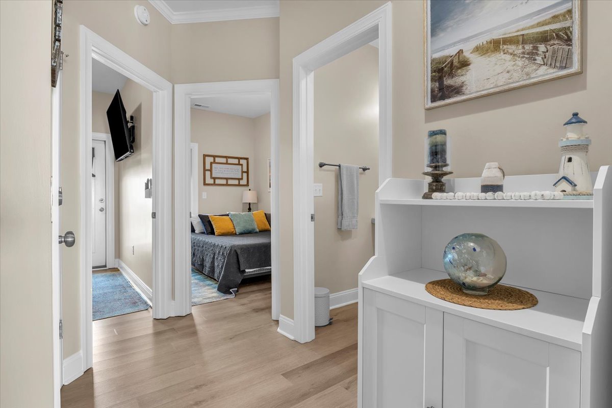 Step into your thoughtfully designed hallway, where coastal artwork and built-in shelving with curated décor create a welcoming atmosphere throughout your stay.