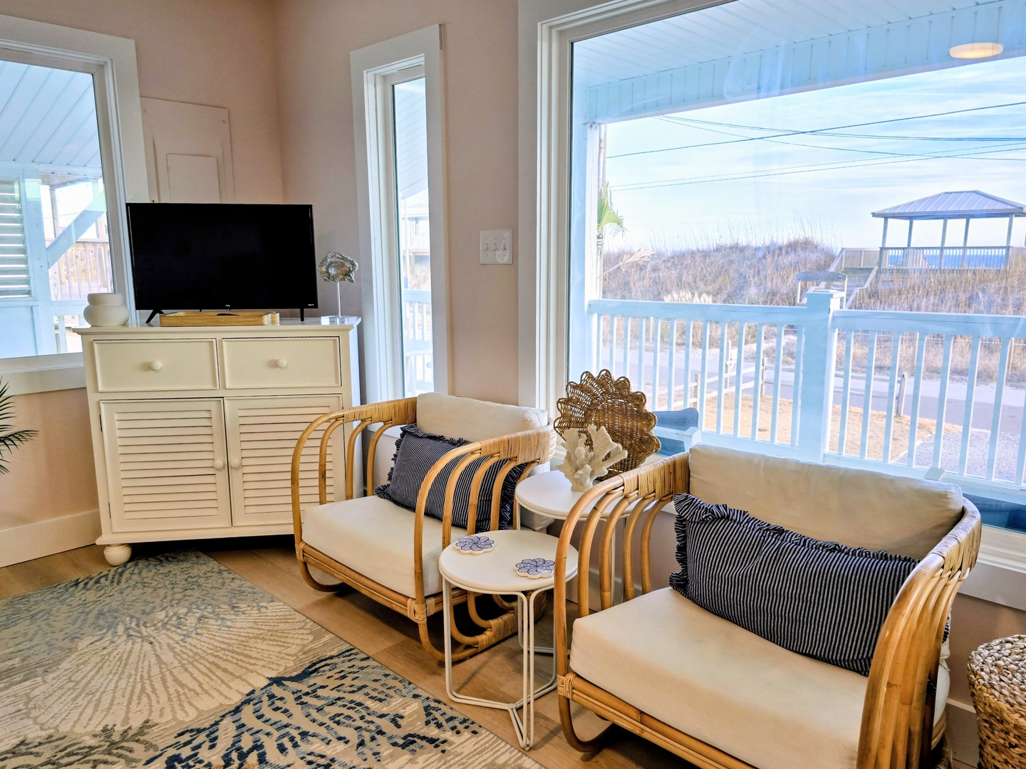 Curl up in your bright coastal living room with stylish rattan seating and unwind while watching TV or gazing at peaceful ocean views.
