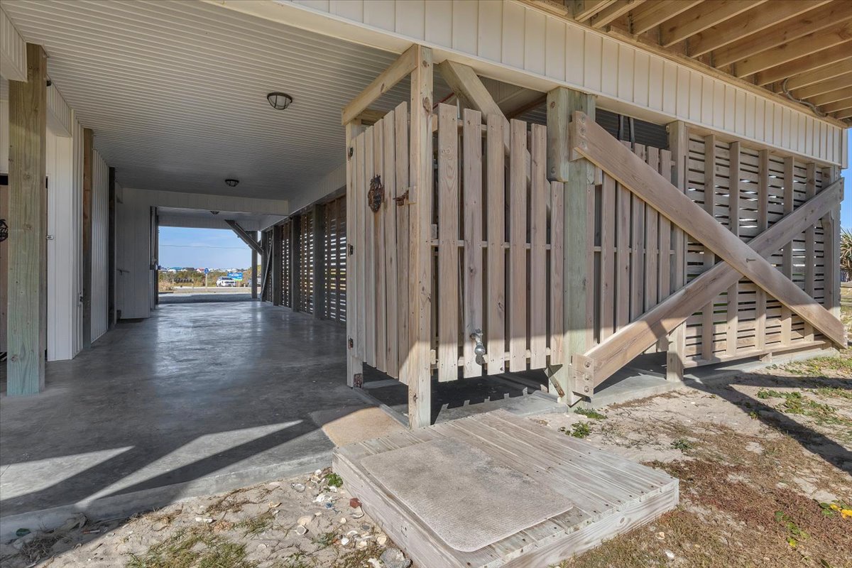 Spacious covered parking area with convenient enclosed storage beneath your elevated beach house retreat.